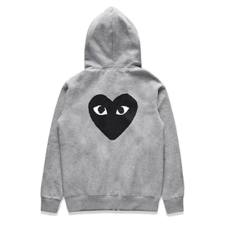 There is a big black heart behind the velvet gray cardigan